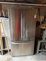 Front view of the LG stainless steel refrigerator with French doors and bottom freezer drawer.