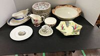 Overview photo showing all items including the large bowl, gravy boat and saucer, side plates, floral creamer, cup and hexagonal dish.