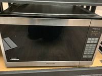 Front view of stainless steel Panasonic microwave oven with black glass door and control panel on the right.