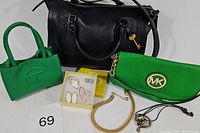Overall lot image showing all items together: black Fossil Parker satchel, two green purses, jewelry box with earrings and bracelet, and gold chain necklace.