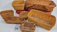 Seven Longaberger woven baskets of various sizes arranged with a white background, showing shapes, handles and sizes.