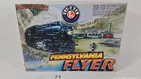 Original box of Lionel Pennsylvania Flyer O gauge train set featuring image of black steam locomotive with headlight, text highlighting powerful headlight, realistic air whistle, and large oval track.