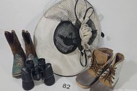 Lot arranged with Kentucky Derby style hat, brown glitter cowboy boots, tan outdoor boots, and black binoculars all visible.