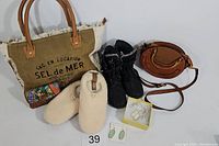 Overview of all items in the lot showing bag, wallet, boots, slippers, and jewelry