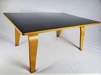 Three-quarter view showing table with black laminate top and birch plywood legs