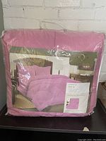 New Clara Clark pink twin XL comforter in plastic packaging with label on front showing product details.