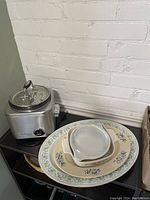 Photo showing Cuisinart rice cooker alongside the platters and bake ware stacked together
