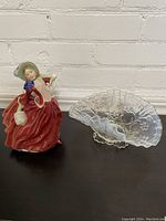 Photo of the Royal Doulton Lady figurine in red dress standing next to the opalescent glass fan dish.