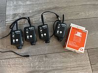 All four transceivers laid out on floor alongside boxed Sony hot shoe adapter