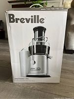 Box front showing Breville Juice Fountain Plus JE98XL with large 3-inch chute and 850 watt motor.