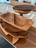 Stacked view of the wooden trays showing different shapes and wood grain finishes.