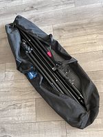 Photo of folded backdrop stand inside black carrying case showing size and compactness.