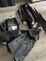 Overview of four softboxes, two light stands, and carrying case laid out on floor