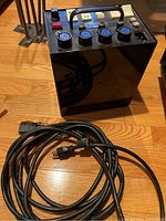 Power pack unit standing on floor with attached power cable