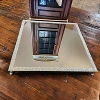 12-inch square mirror tray placed on a wooden table, showing complete reflective surface and beaded edge in good condition.