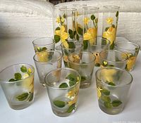 All 15 hand-painted glasses shown together with yellow floral and green leaf designs.