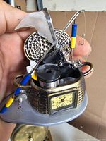 Close-up of mini clock fishing basket showing woven basket texture, fishing rods, net, and fishing line spool.