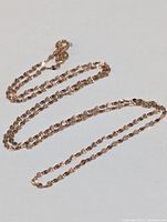 Full view of the 18K rose gold chain laid out on a white surface showing the length and link details.