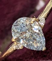 Close-up of pear-shaped lab diamond on 10K yellow gold band at angle