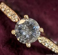 Closeup of center diamond and accent stones on band