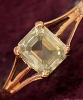 Close-up front view of emerald-cut diamond in four-prong setting.