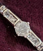 Close-up view of the sterling silver ring with 0.25 carat diamond center and smaller diamonds on band.