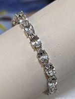 Close-up of green amethyst stones set in sterling silver links showing clarity and cut.