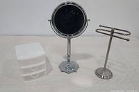 White drawer container, magnifying mirror, and chrome hand towel rack shown together on white background.