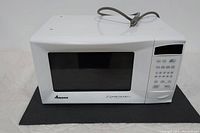 Front view of white Amana Radarange microwave oven with black windowed door and control panel on right side.