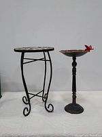 Full view of the round outdoor metal scrollwork side table and cast iron bird bath/feeder.