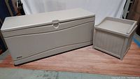Both storage boxes side by side showing size difference, beige plastic, closed lids