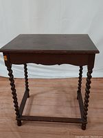 Full front view of the antique wooden table showing barley twist legs and flat rectangular top