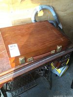 Closed wooden case showing brass latches and handle.