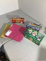 Wide shot showing pink and gold binders, two unopened boxes, and one box with open packs of baseball cards.