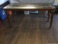 Full view of the wooden washtub stand converted coffee table showing legs and glass top.