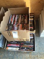 Photo showing one box filled with DVDs standing upright, revealing titles such as End of Watch, The Enemy Below, and Standoff.