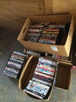 6 boxes containing DVD movies stacked showing spines and covers. Various titles and genres visible.