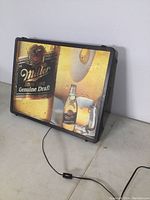 Front view of illuminated sign showing Miller High Life Genuine Draft graphic