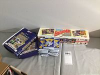 Full lot showing two unopened O-Pee-Chee baseball card boxes, a row of 19 sealed Score baseball card packs, and a Donruss boxed card set with puzzle.