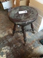 View from above showing round wooden top with worn finish and scratches.