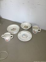 Overview photo of the 2 bowls, plate, and 2 mugs arranged on a surface