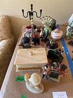 Overview of various small decorative items including onyx pieces, ceramic animals, a candelabra, and cloisonné birds.