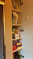 Shelf showing assorted boxes and bottles of bathroom and health aid items inside a cabinet