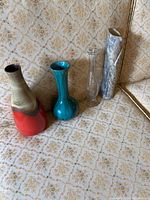 Four vases shown together on patterned fabric background.
