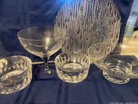 Wide view of lot showing large stemmed glass, small dishes, a textured oval dish and plates.