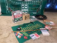 Full lot overview showing roulette wheel, chip sets, card decks, game boards and Tripoley set
