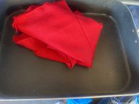 Roasting pan with red cloth napkins inside showing color and fabric detail of napkins.