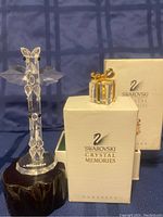 Swarovski Crystal Alaska totem pole on black wooden base with 'Alaska' engraved, next to the Swarovski Crystal Memories mini gift box in original packaging