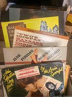Photo showing vinyl records with titles including Two's Company featuring Maynard Ferguson, Jane Fonda's Workout Record, John Sebastian's 'The Magic Book Vol 1', and Baroque Orchestra Works.