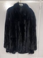 Front view of the reversible coat showing plush black fabric side.